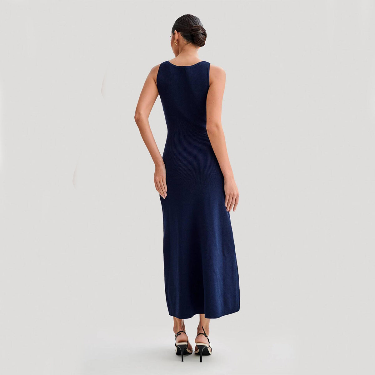 Elegant knitted sleeveless dress for women, featuring a slim fit, round neck, and single-breasted design. Long fashion dress in a chic style.