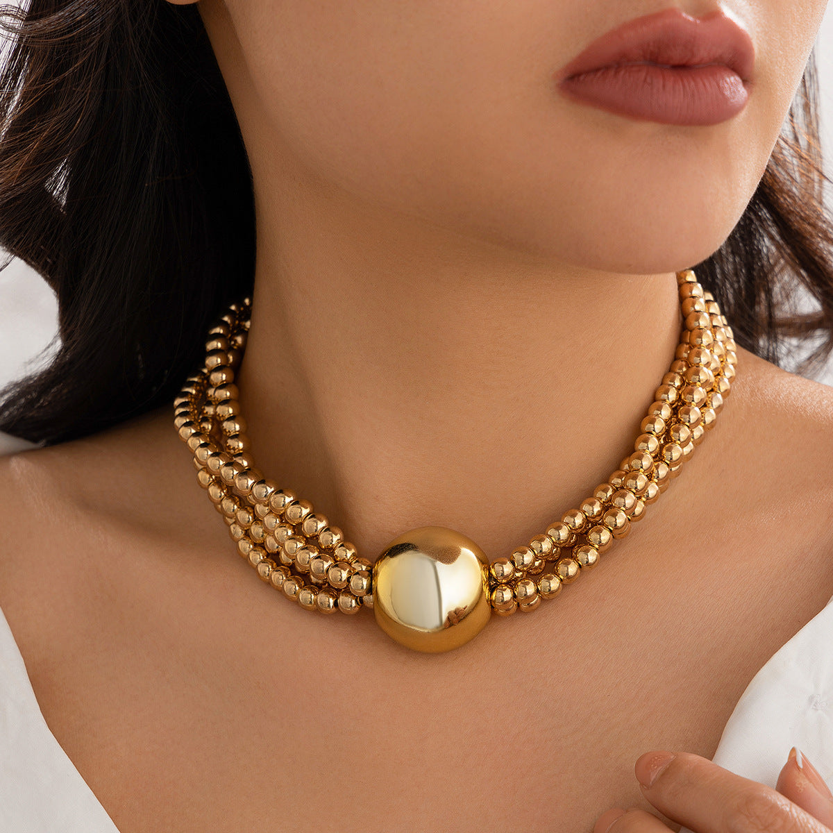 European American multi-layer necklace featuring a bold ball pendant