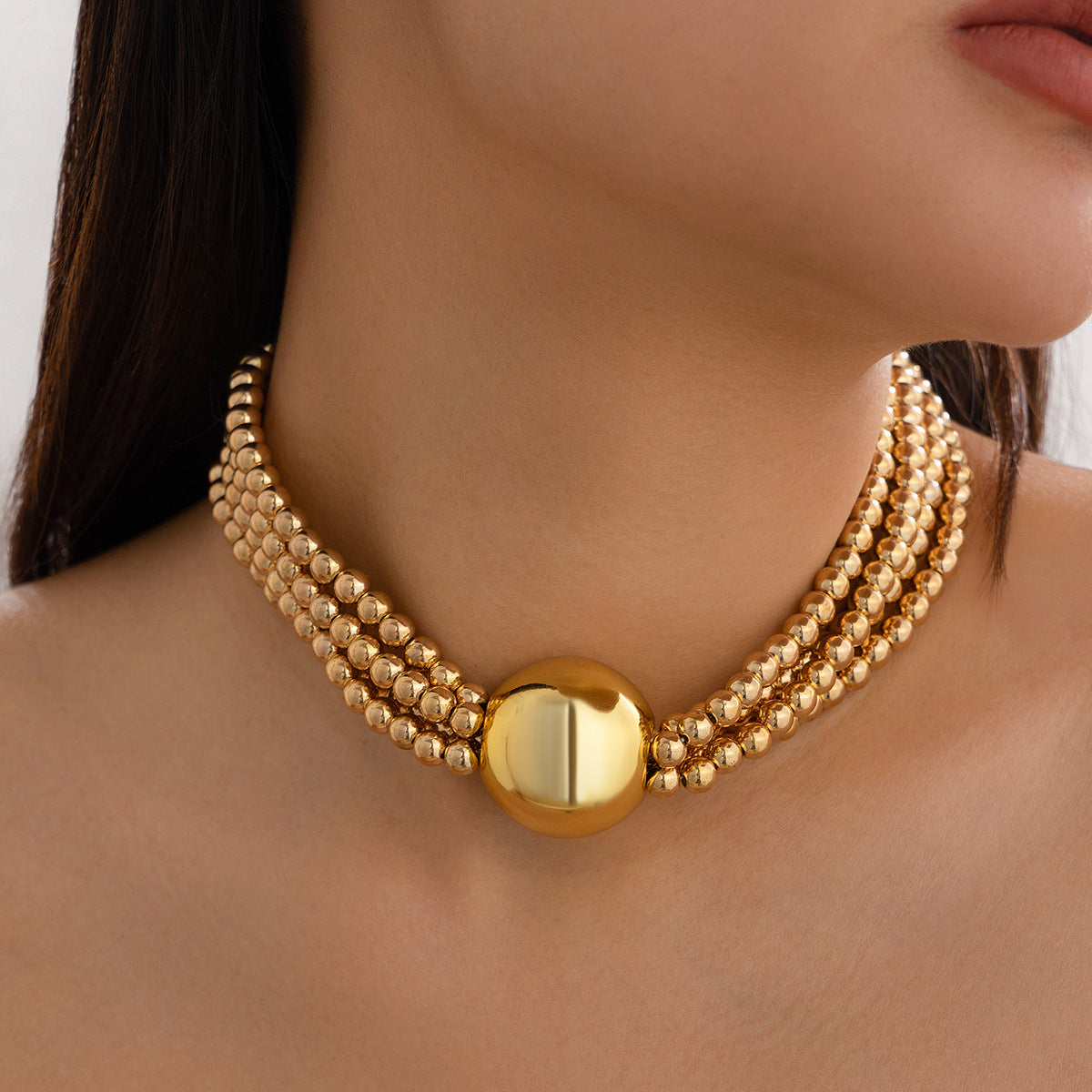 European American multi-layer necklace featuring a bold ball pendant